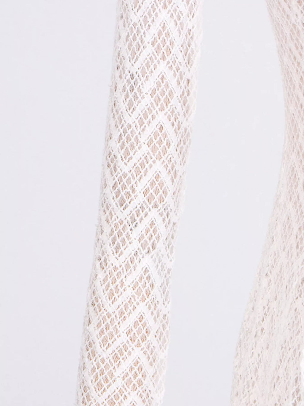 White lace long-sleeve fabric close-up with diamond trellis pattern