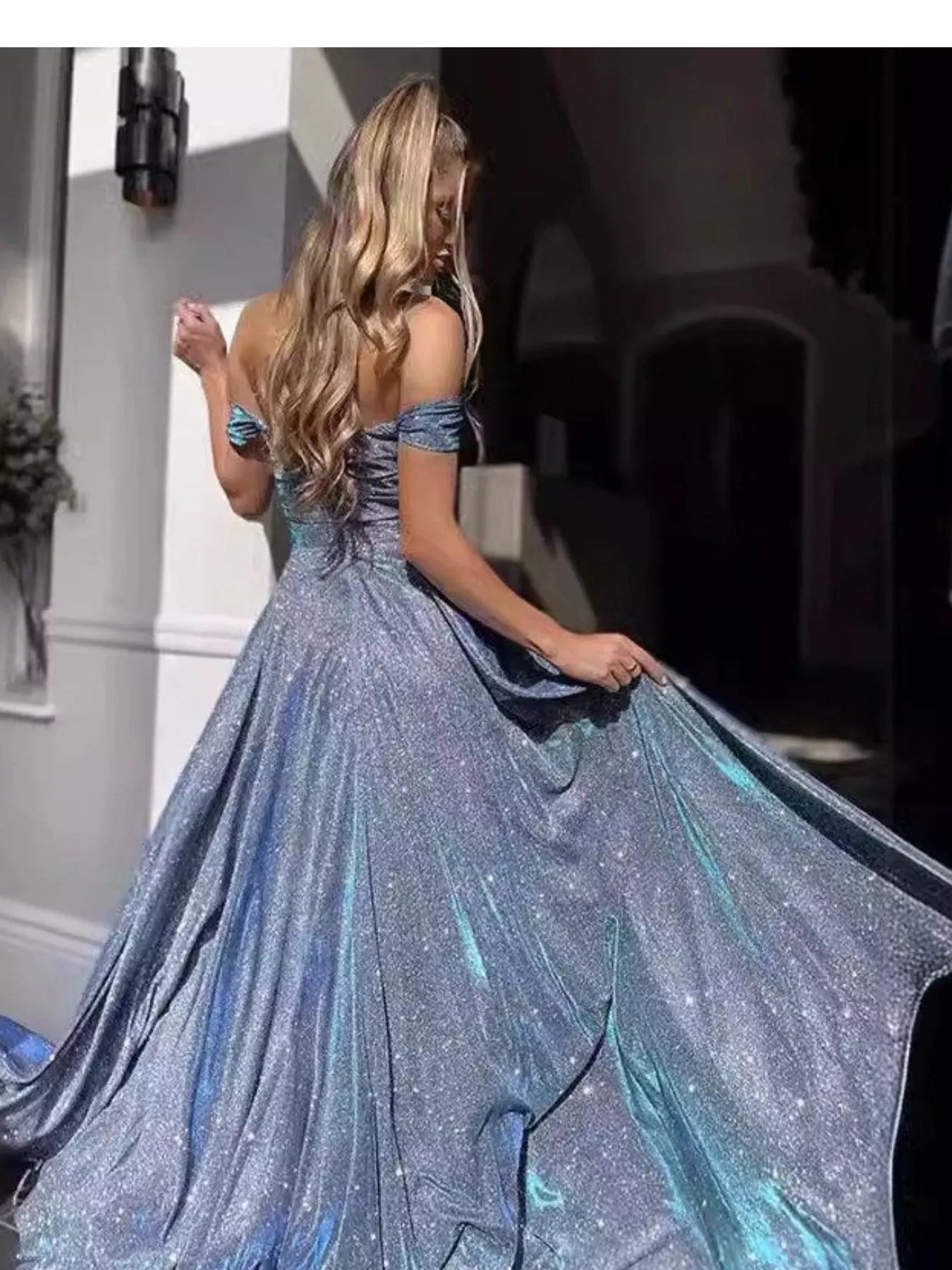 Light blue off-shoulder glitter maxi dress with flared skirt and high slit, back view