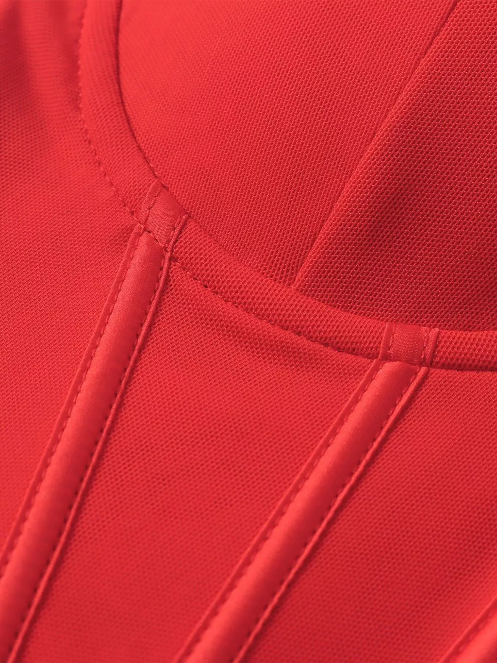 Close-up of red sweetheart bodice seam detailing and ruched vertical paneling
