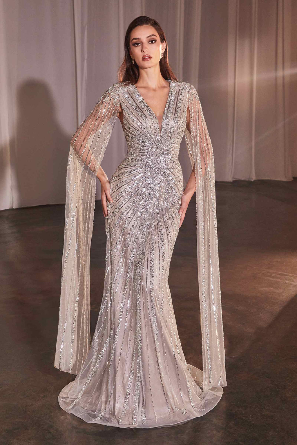 Silver sequin sheath gown with long V-neck, sheer cape sleeves, and flowing skirt slit
