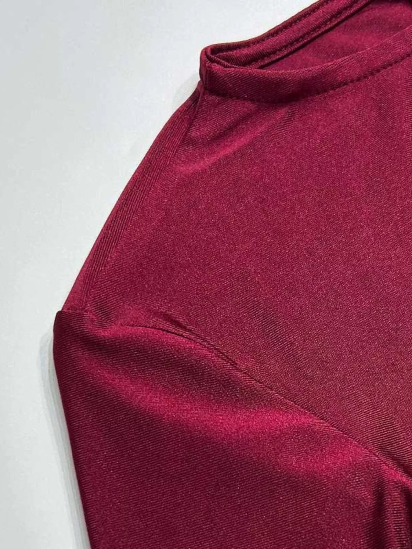 Burgundy ruched maxi dress fabric close-up with high neckline and draped seam
