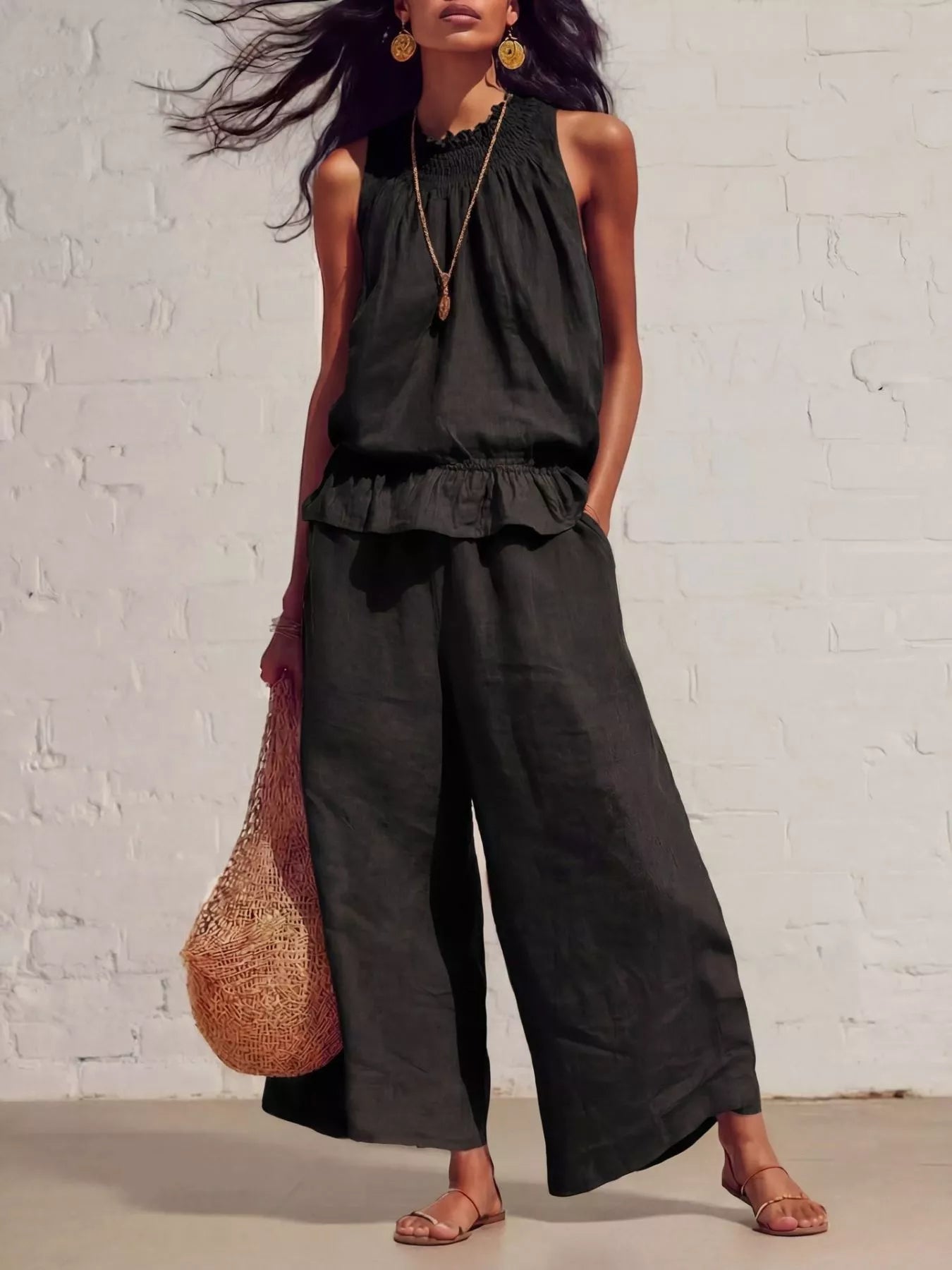 Black sleeveless smocked ruffled hem top and wide-leg pants set with tiered bottom.