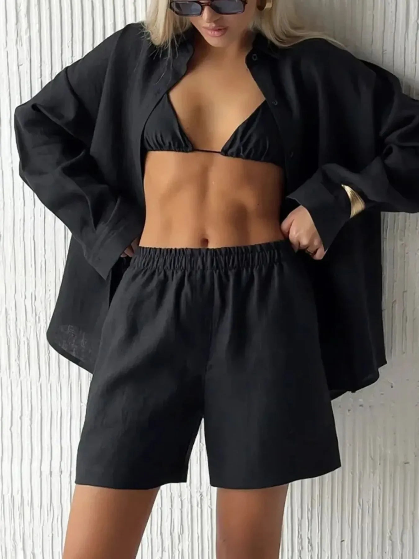 Black button-up long-sleeve shirt worn open with matching elastic-waist shorts set