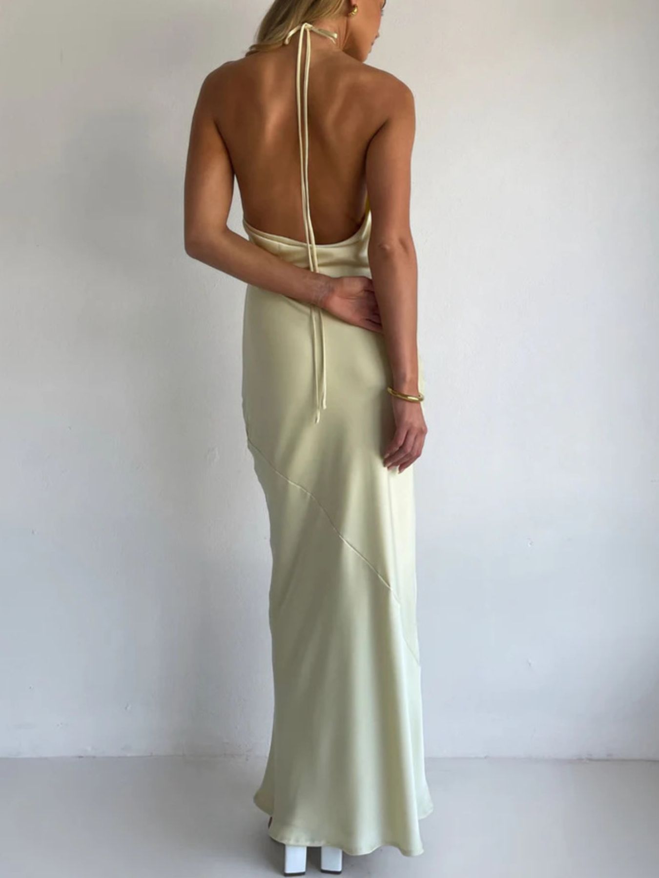 Light yellow satin halter maxi dress with open back and thin tie straps