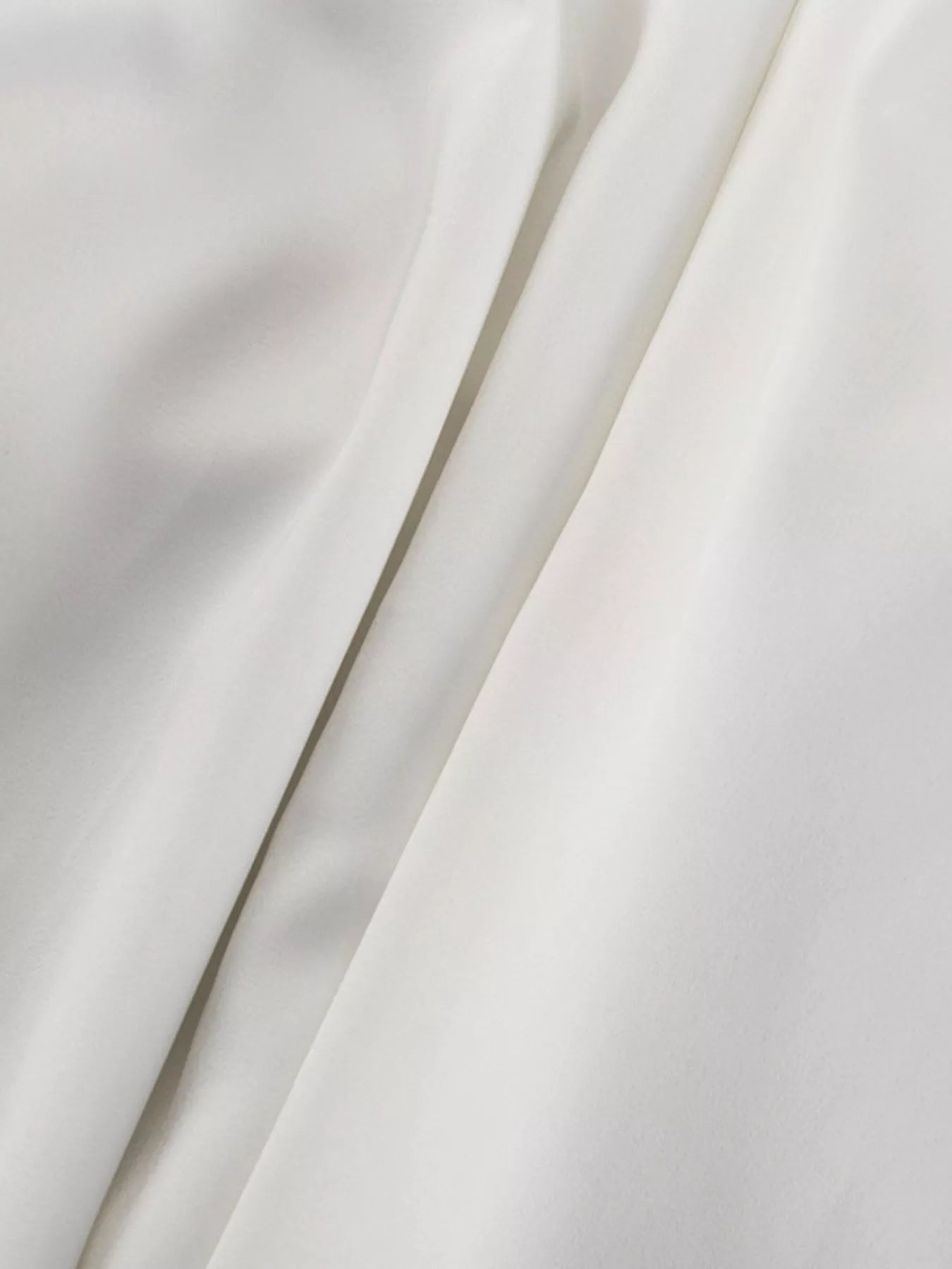 White halter neck mini dress close-up of fabric drape across bodice