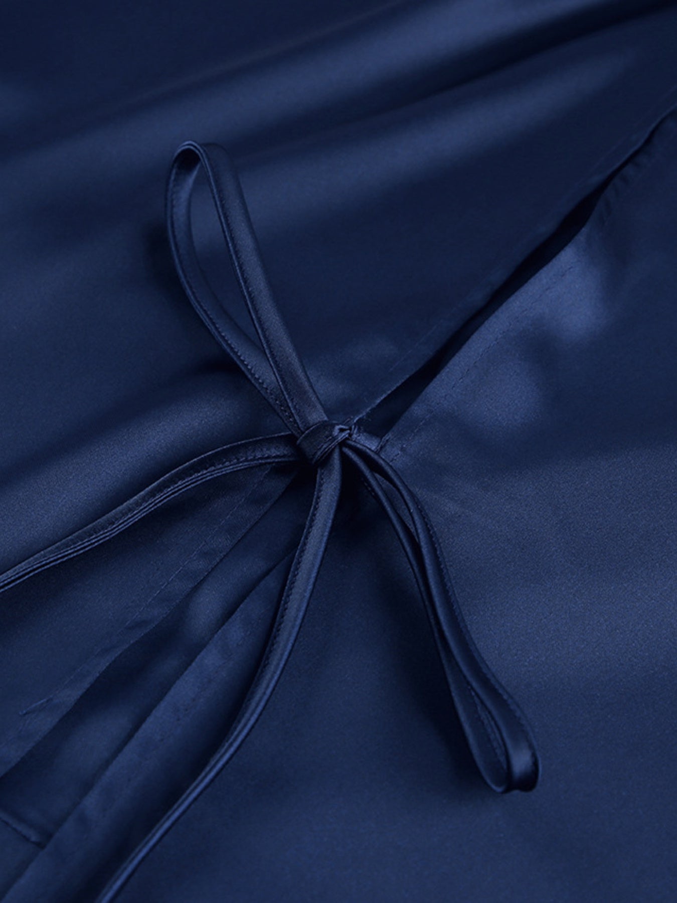 Navy mini dress close-up of waist tie bow detail and gathered fabric