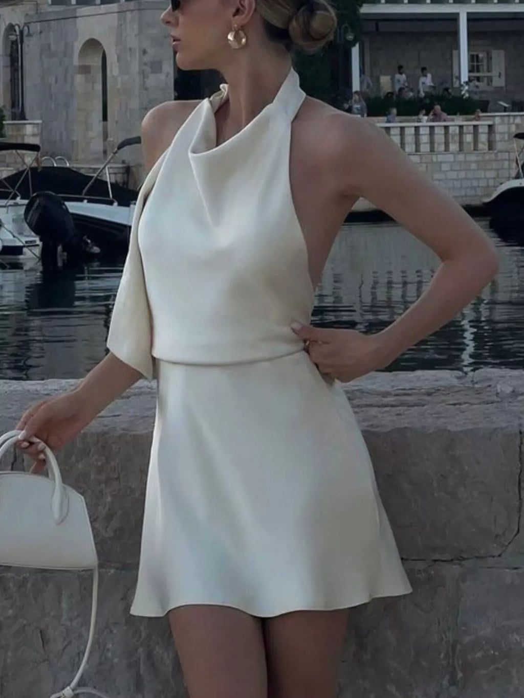 White halter neck mini dress with sleeveless cut and fitted waist, flared skirt