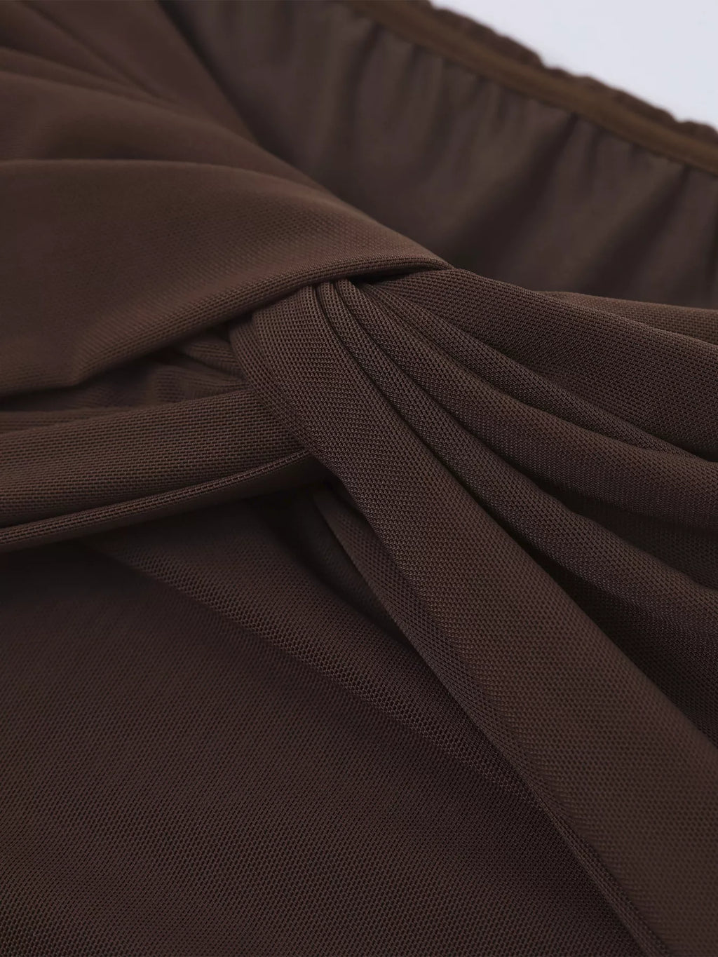 Close-up of brown ruched fabric on an off-shoulder maxi dress