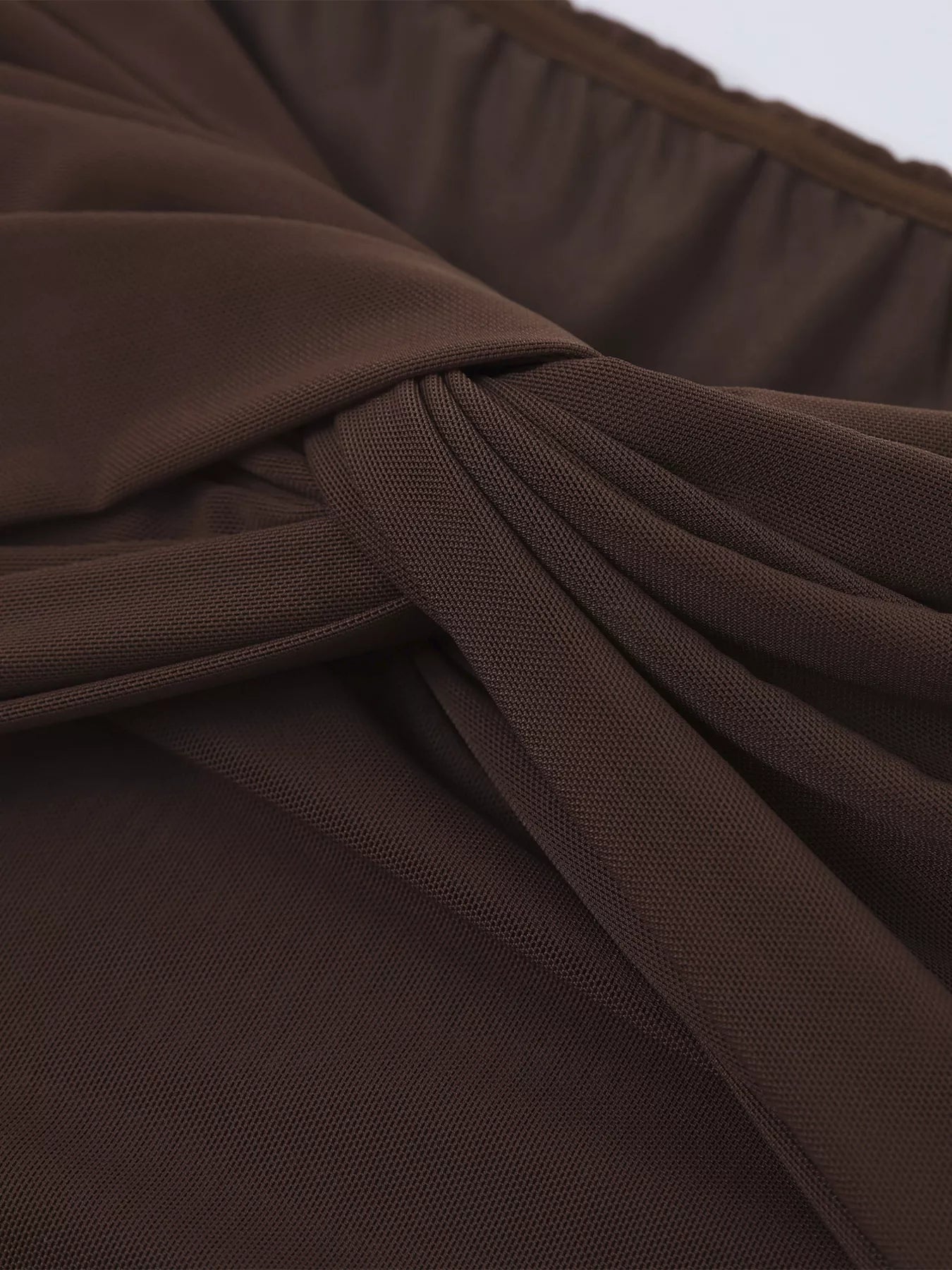 Close-up of brown ruched fabric on an off-shoulder maxi dress