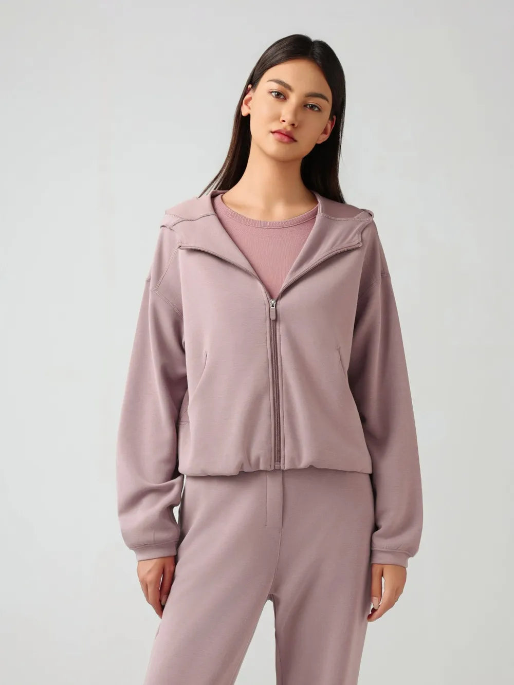Dusty pink zip-up active hoodie with hood and front zipper, relaxed dropped-shoulder fit.