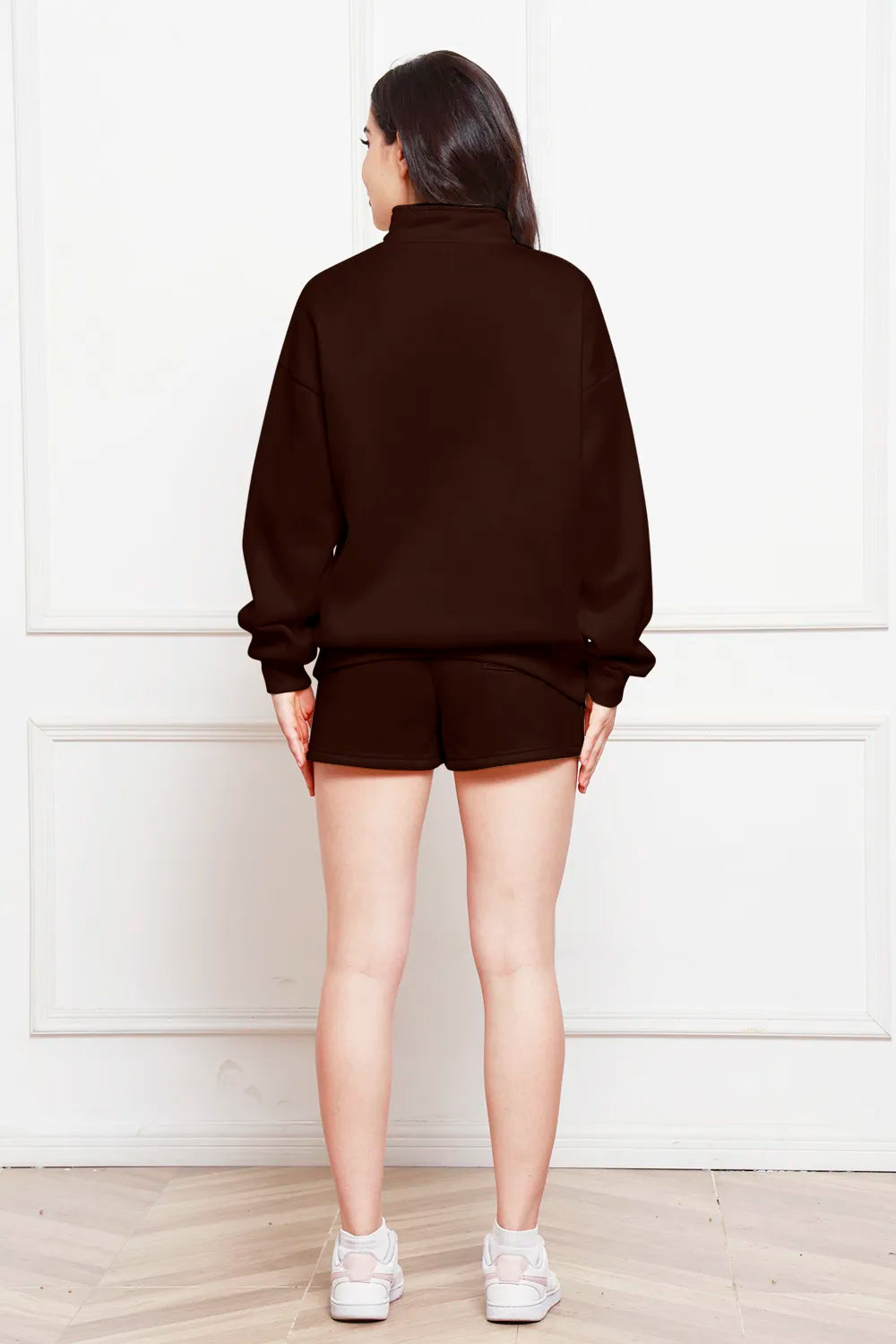 Chocolate half-zip long-sleeve sweatshirt and drawstring shorts, back view.