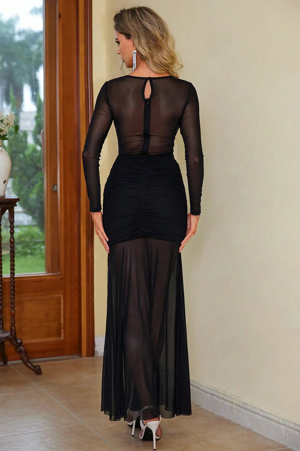 Black semi-sheer dress with round neck, long sleeves, keyhole back, ruched slit.