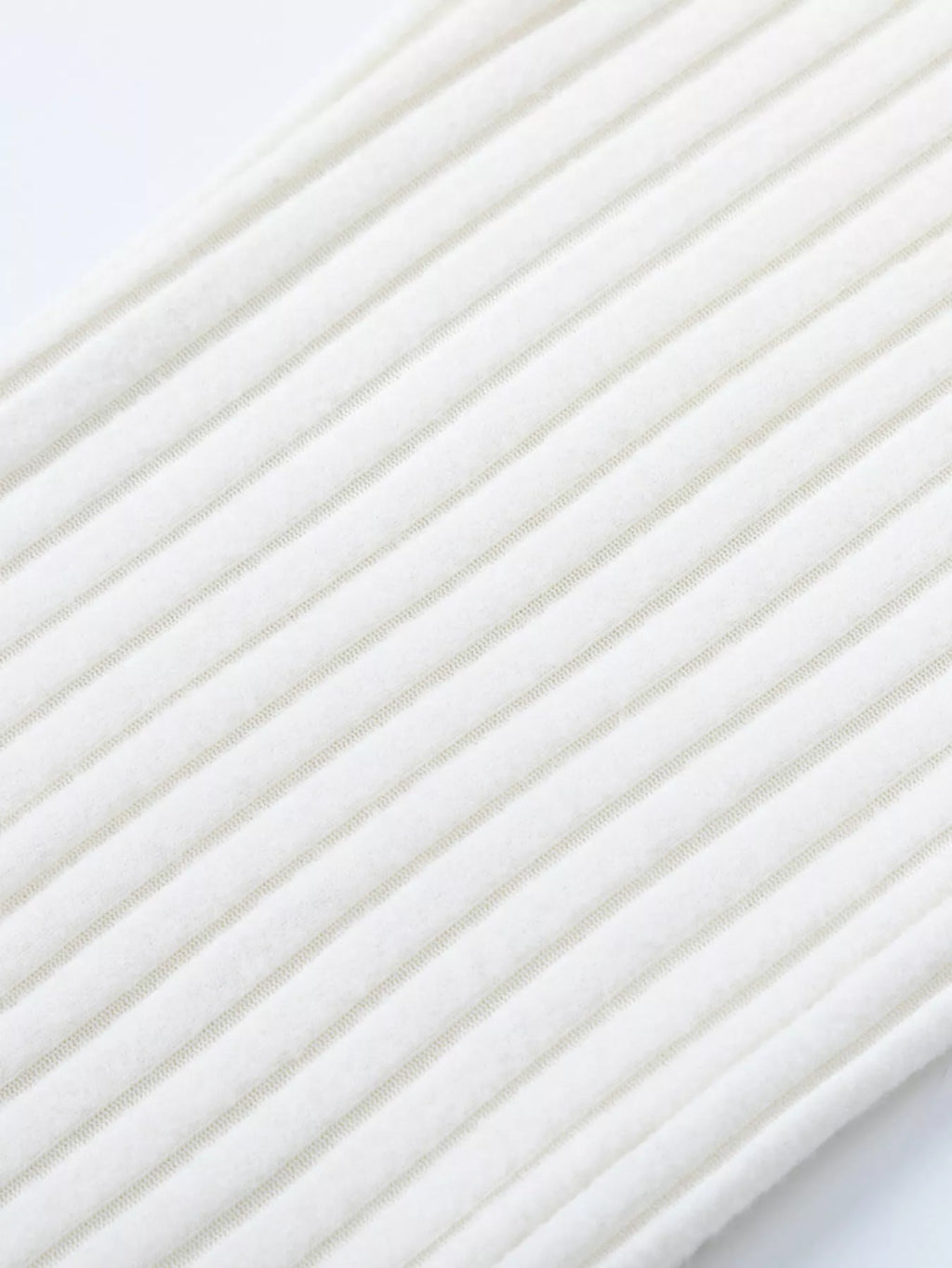 Close-up of white ribbed knit texture with narrow vertical stripes