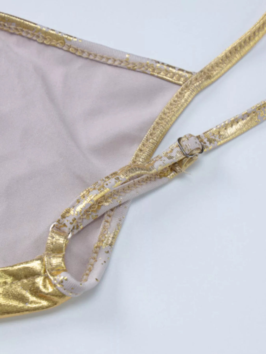 Gold backless V-neck maxi dress close-up: strap and neckline trim detail