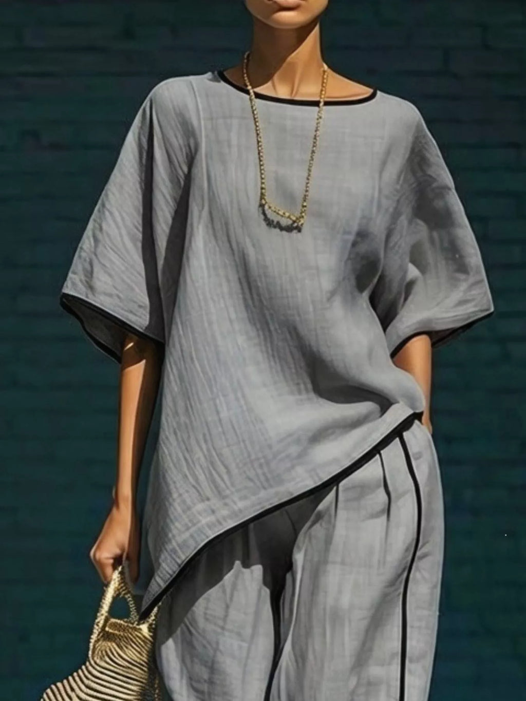 Round-neck top and pants set in light gray with dark contrast trim and loose drape fit