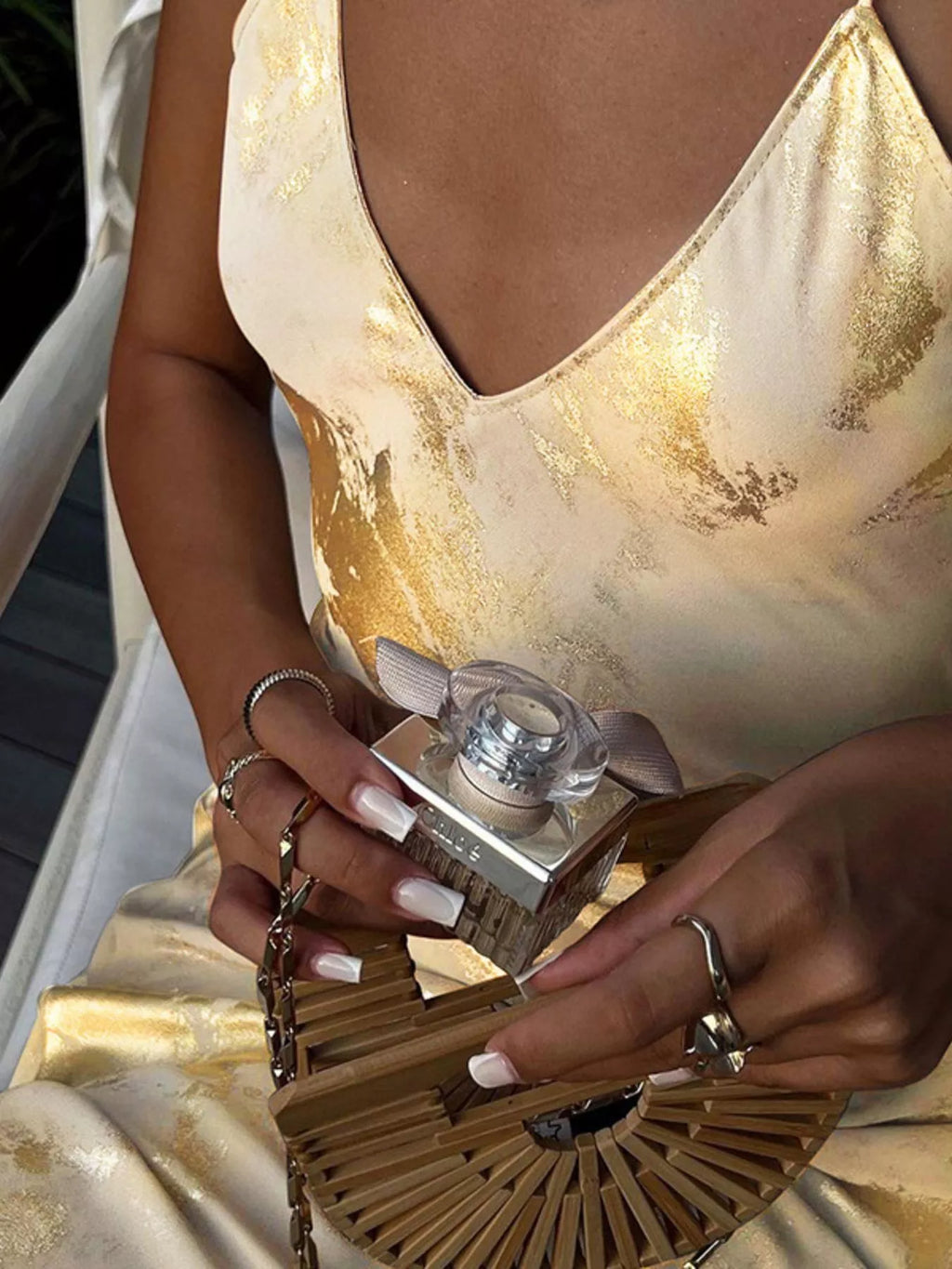 Gold backless V-neck maxi dress close-up: V-neckline and metallic floral-like pattern