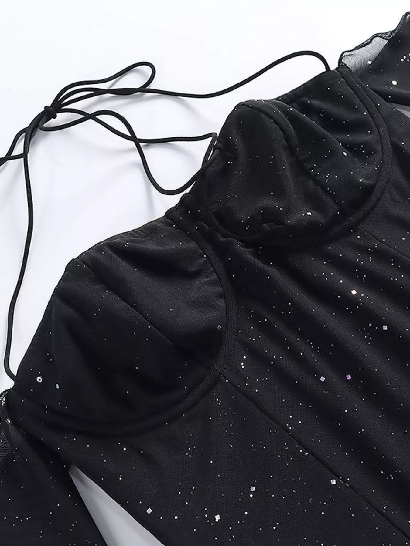 Black glitter mini dress detail: sweetheart cups, thin straps, and dotted sparkle pattern