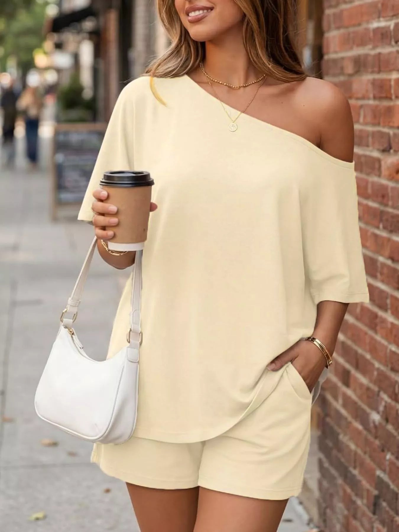 Light beige one-shoulder top and matching shorts set with asymmetrical neckline.