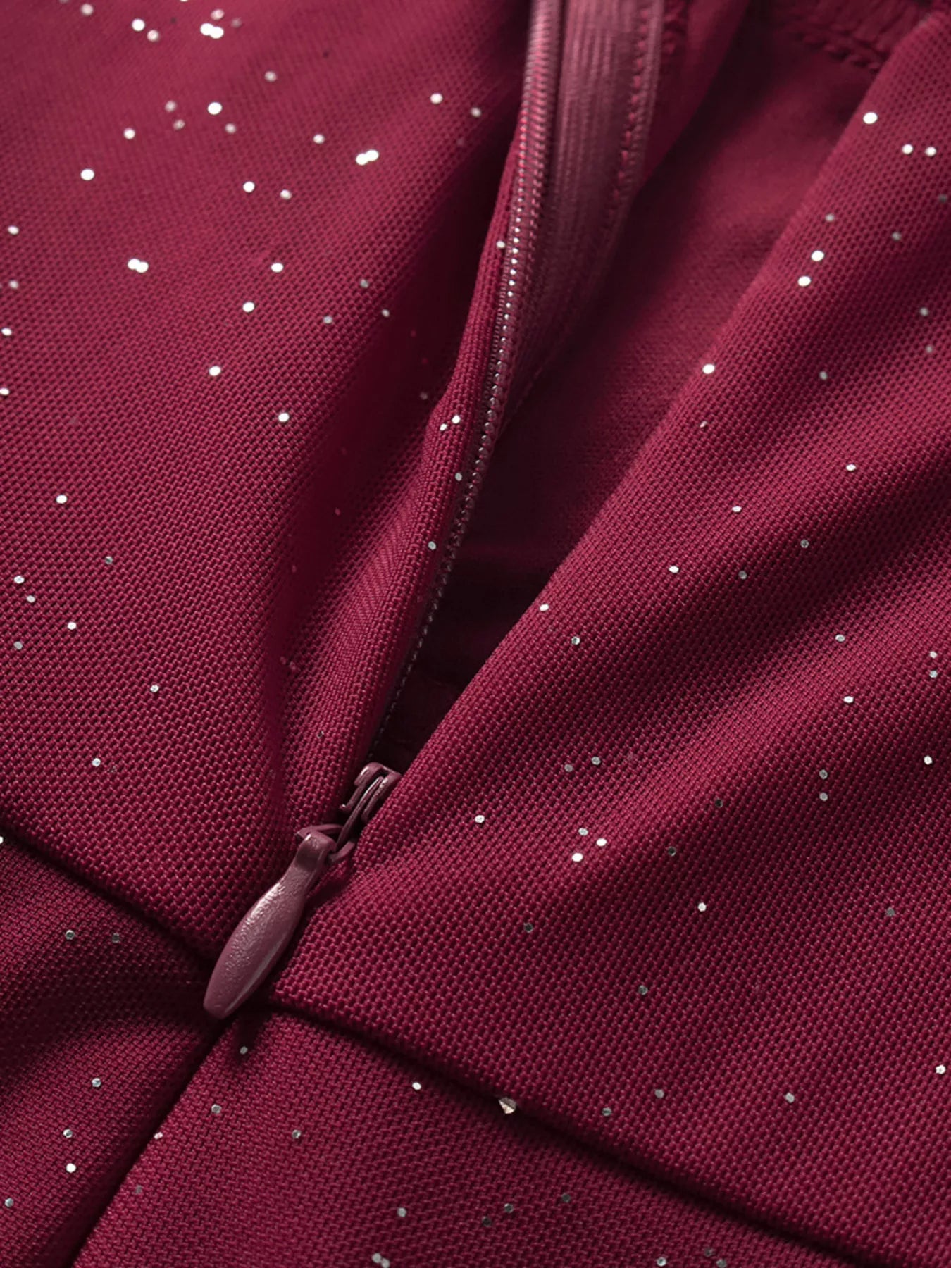 Close-up of burgundy glitter zipper and seam detail