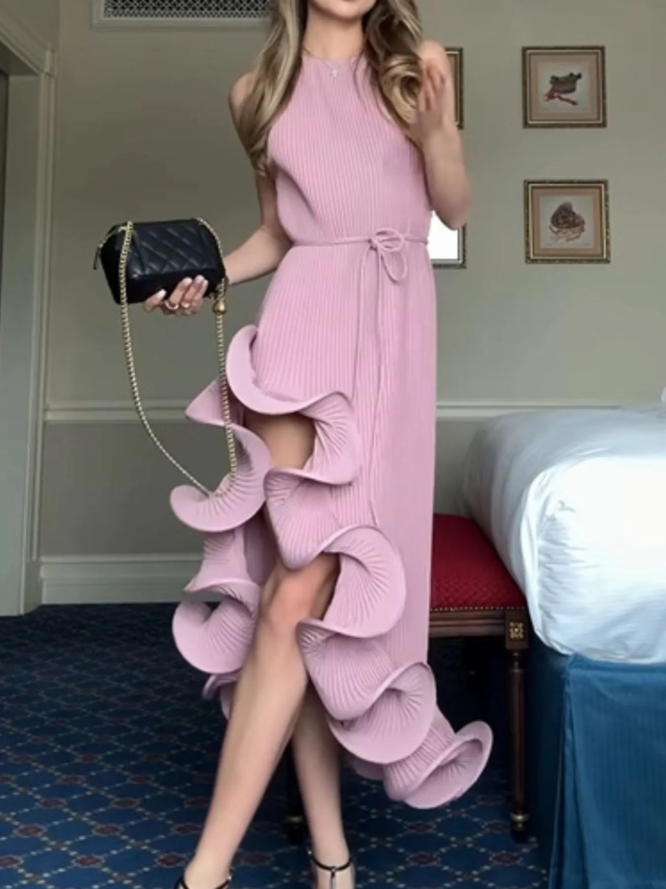 Pink ribbed sleeveless dress with ruffle hem and tie waist, large cascading ruffle detail