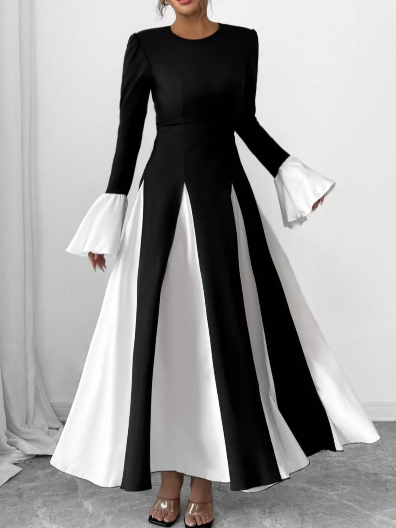 Black maxi dress with round neck and flared skirt, white contrast sleeve cuffs