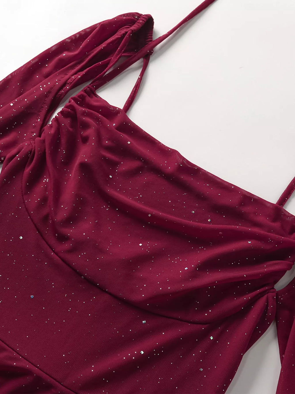 Burgundy glitter fabric drape detail from a maxi dress