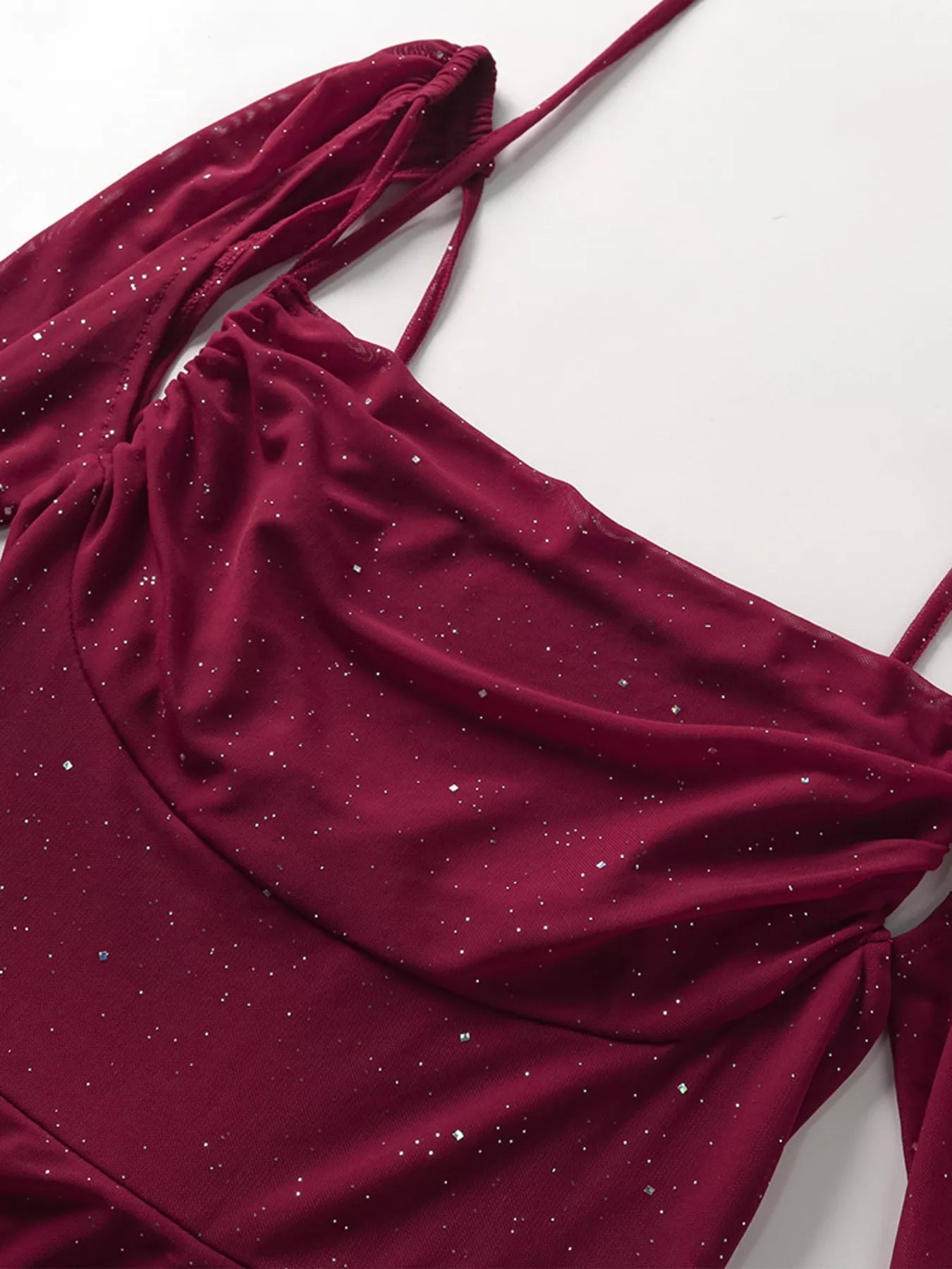 Burgundy glitter fabric drape detail from a maxi dress