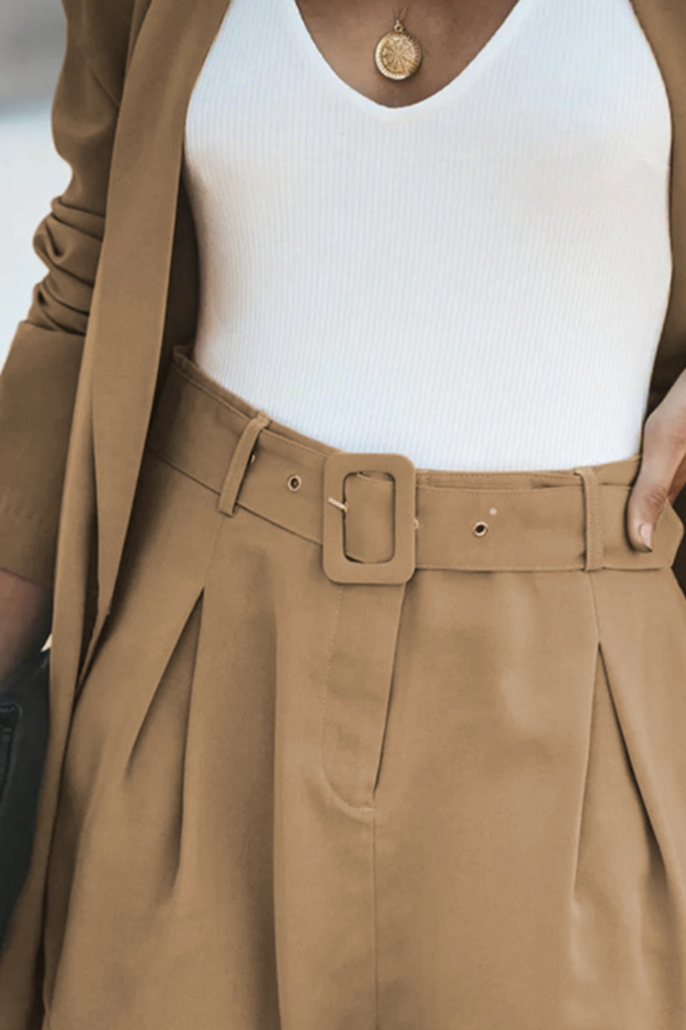 Camel shorts with belt buckle and button closure under a longline blazer