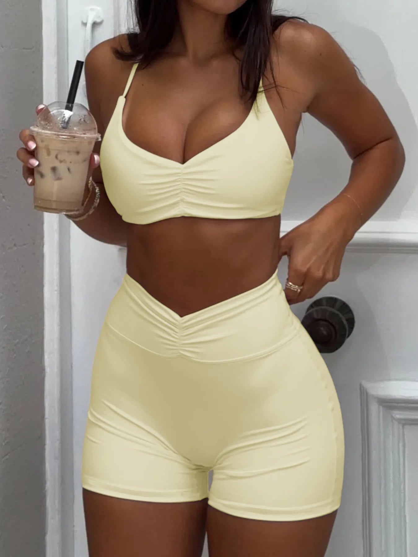 Ruched sports bra and high-waisted shorts set in pale yellow, ruched front bra