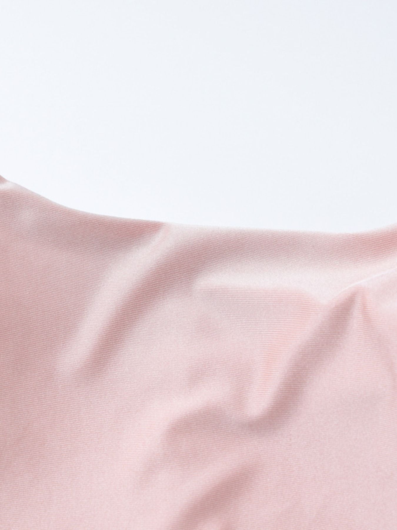 Soft pink satin-like fabric close-up with gathered ruched texture