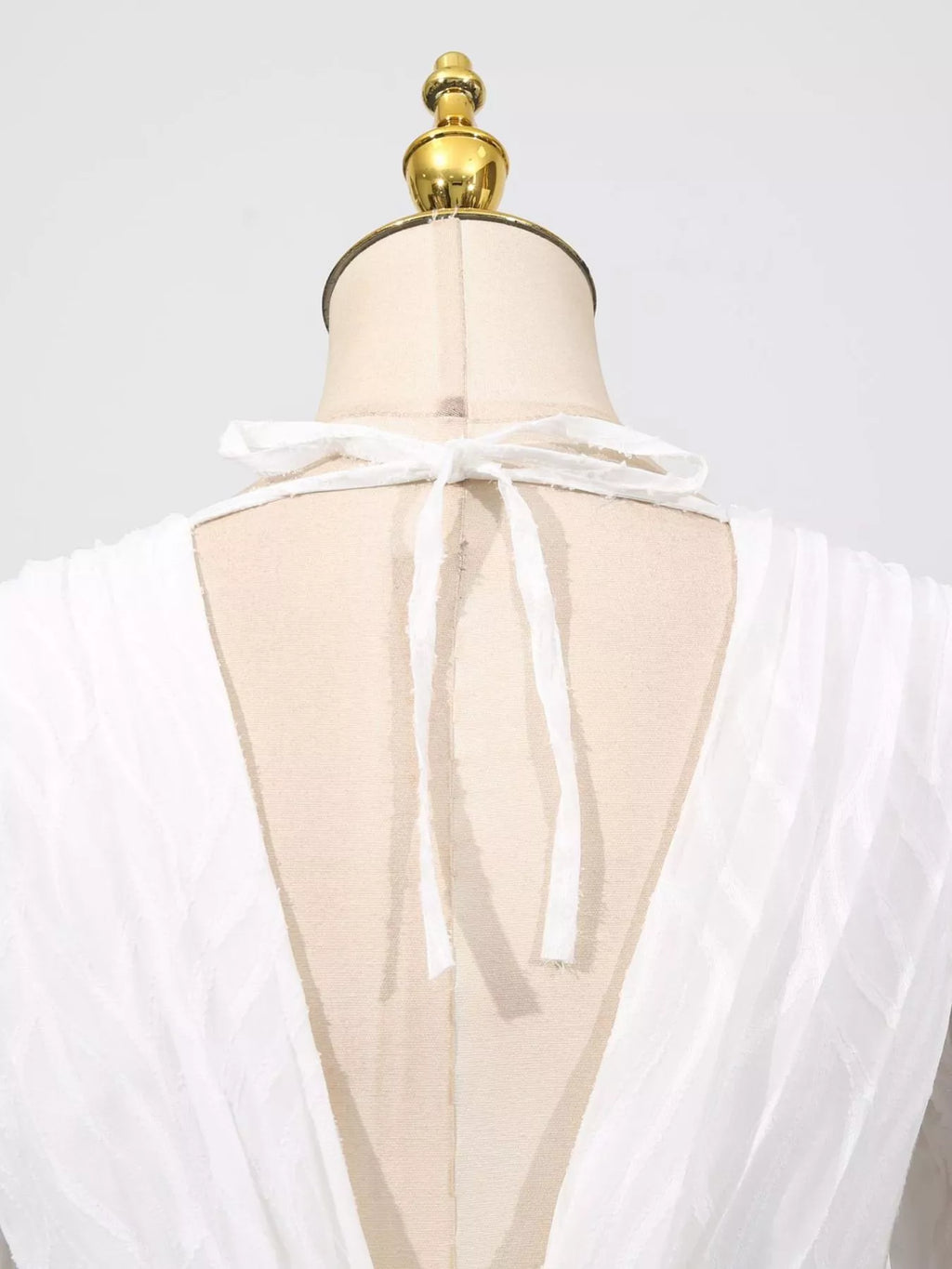 White open-back V with tie detail and sheer layered overlay