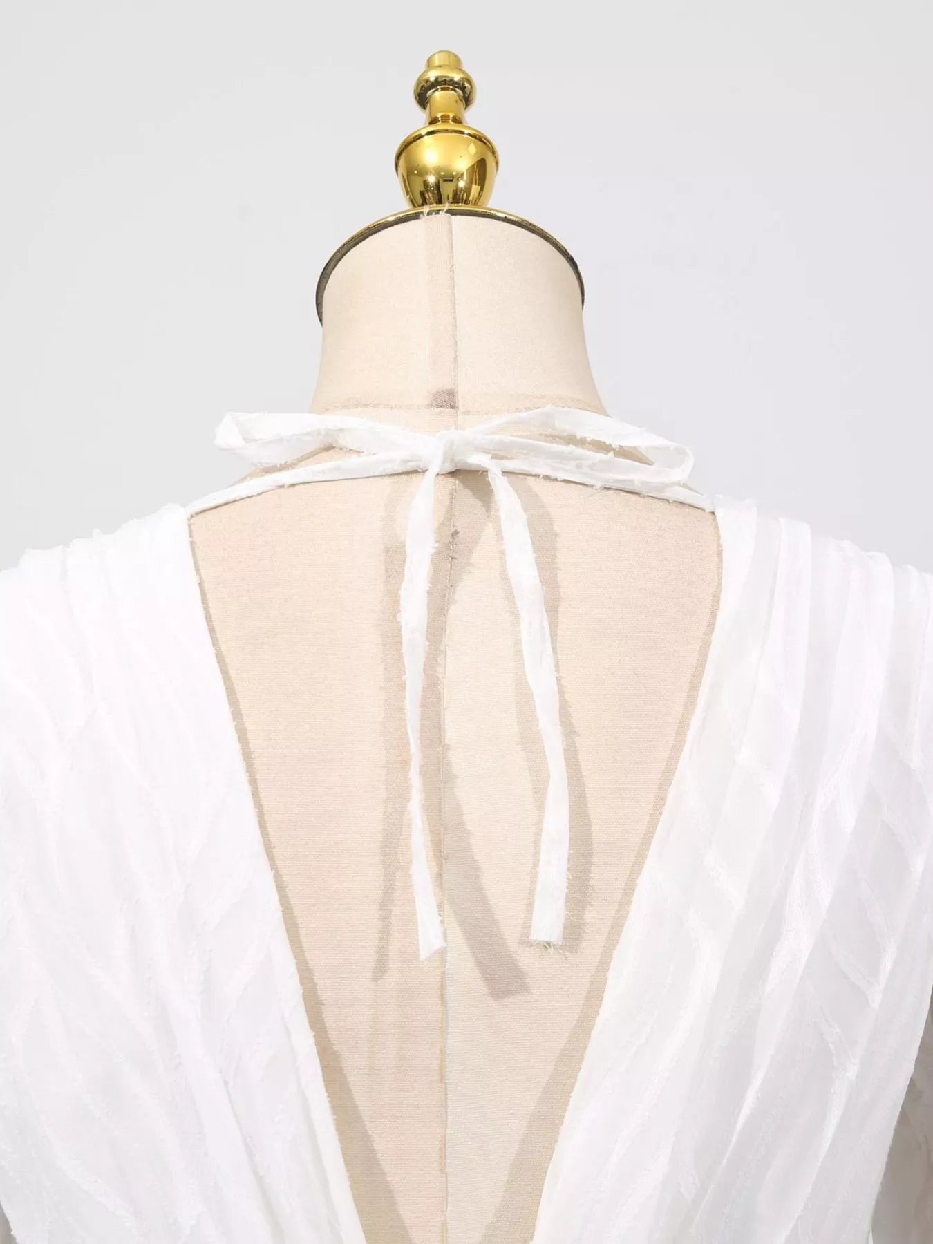 White open-back V with tie detail and sheer layered overlay