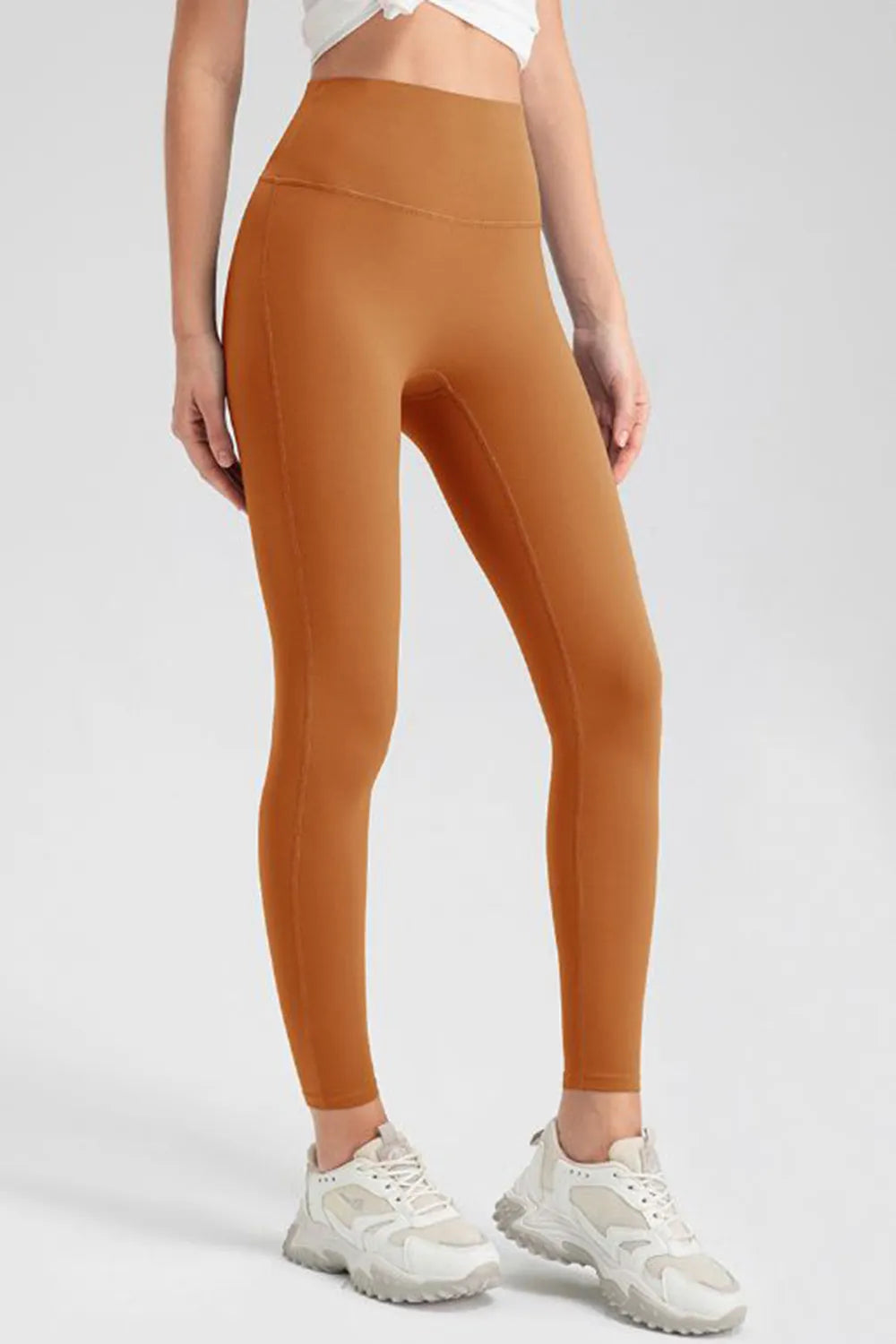 High-waist skinny active pants in caramel orange, front view, ankle length.