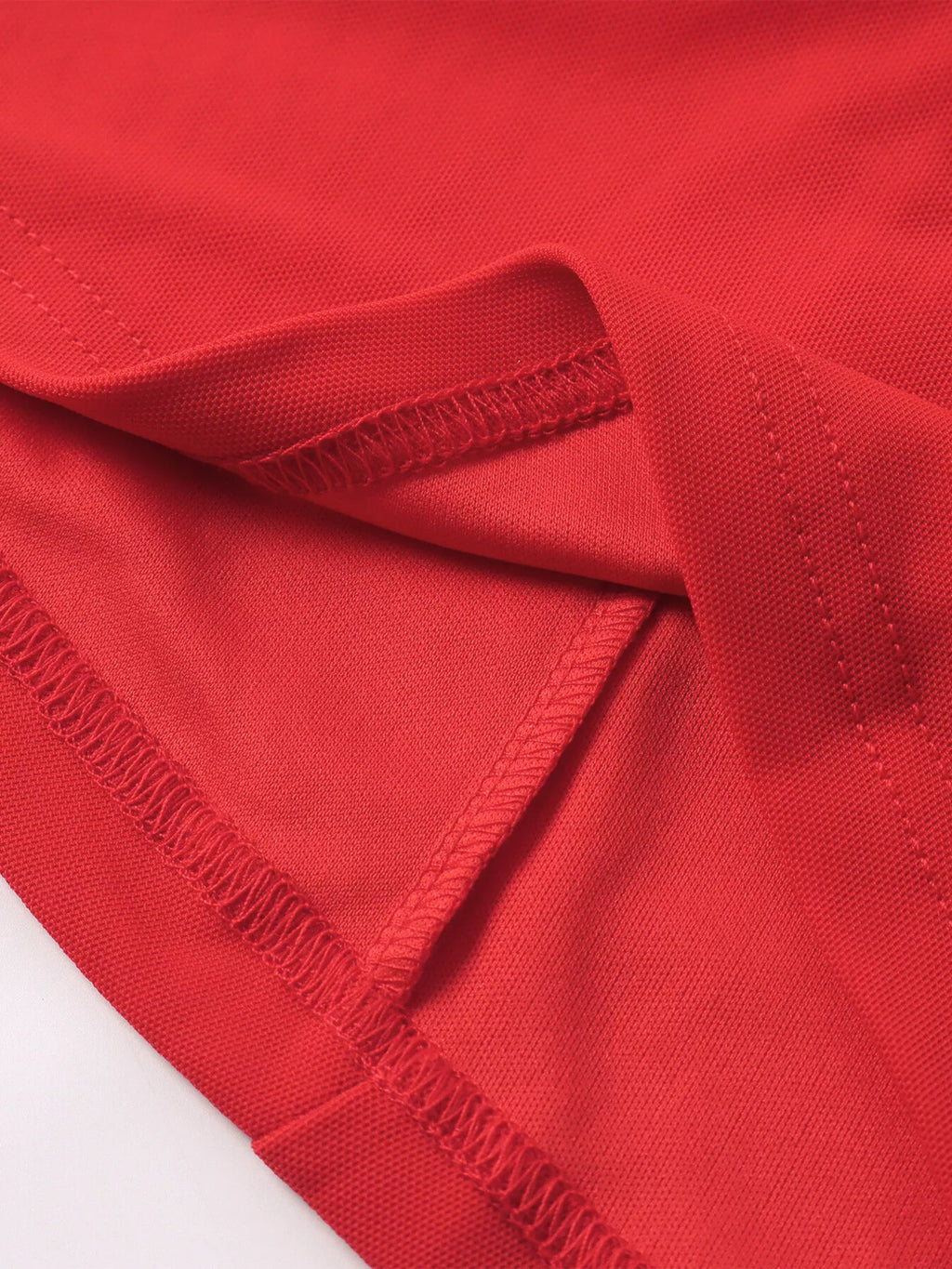 Red ruched halter mini dress fabric closeup with gathered seam detail