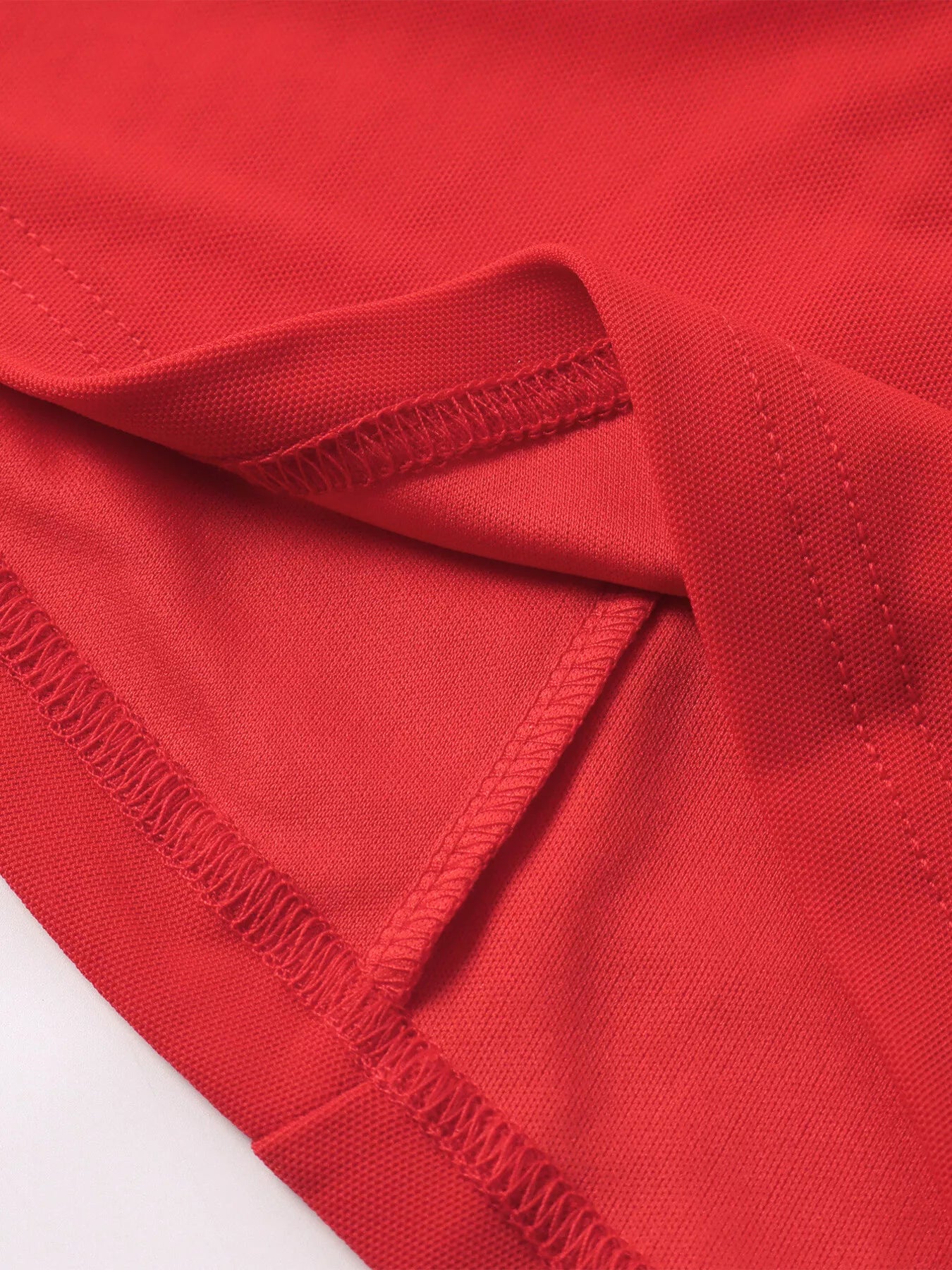 Red ruched halter mini dress fabric closeup with gathered seam detail