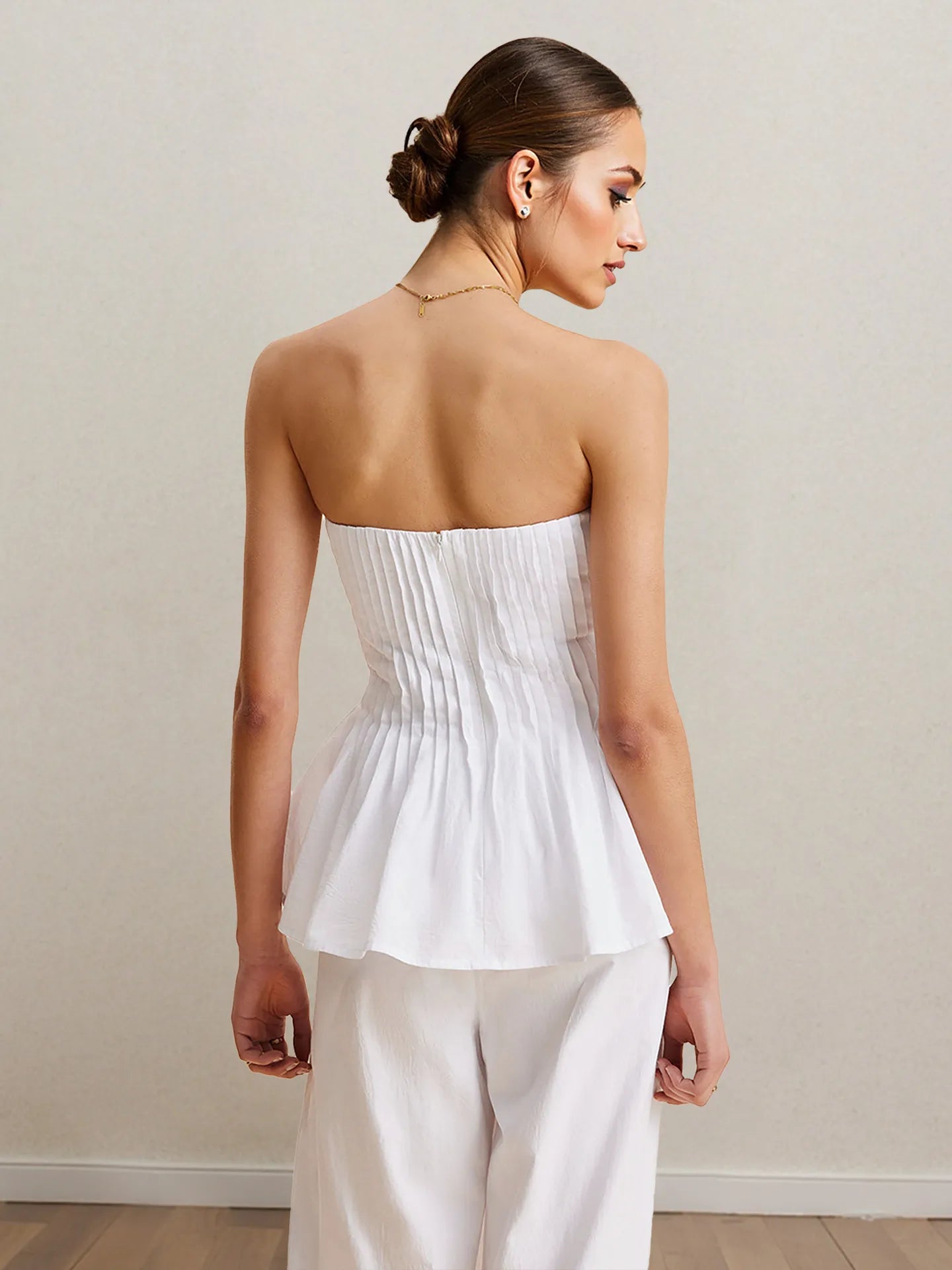 White strapless peplum top and wide-leg pants set, back view with gathered peplum.