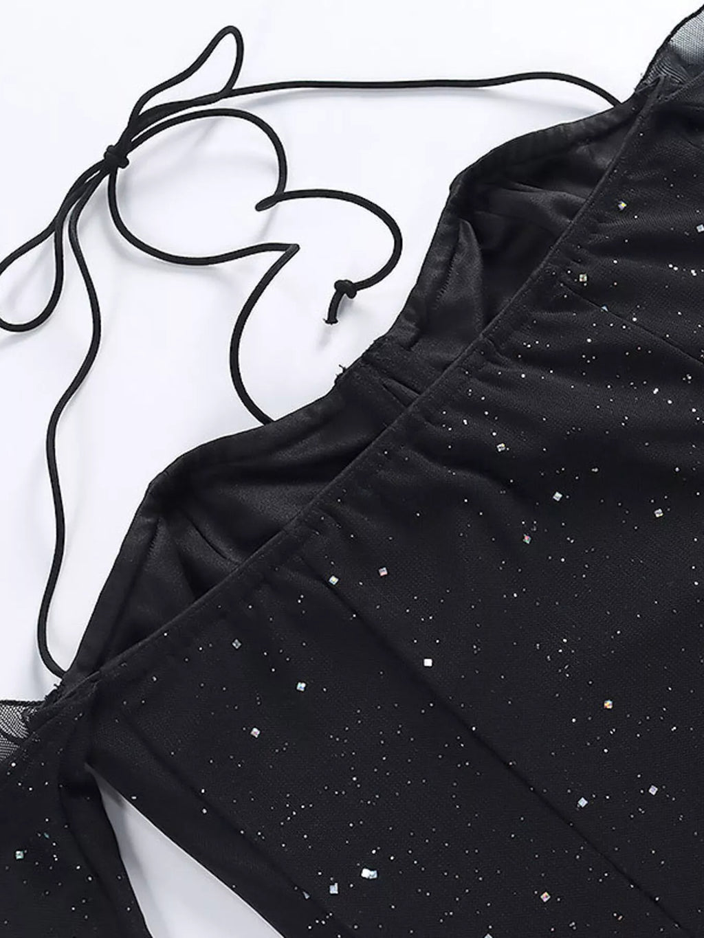 Close-up of black glitter mini dress with sheer mesh texture and sparkly dot detail