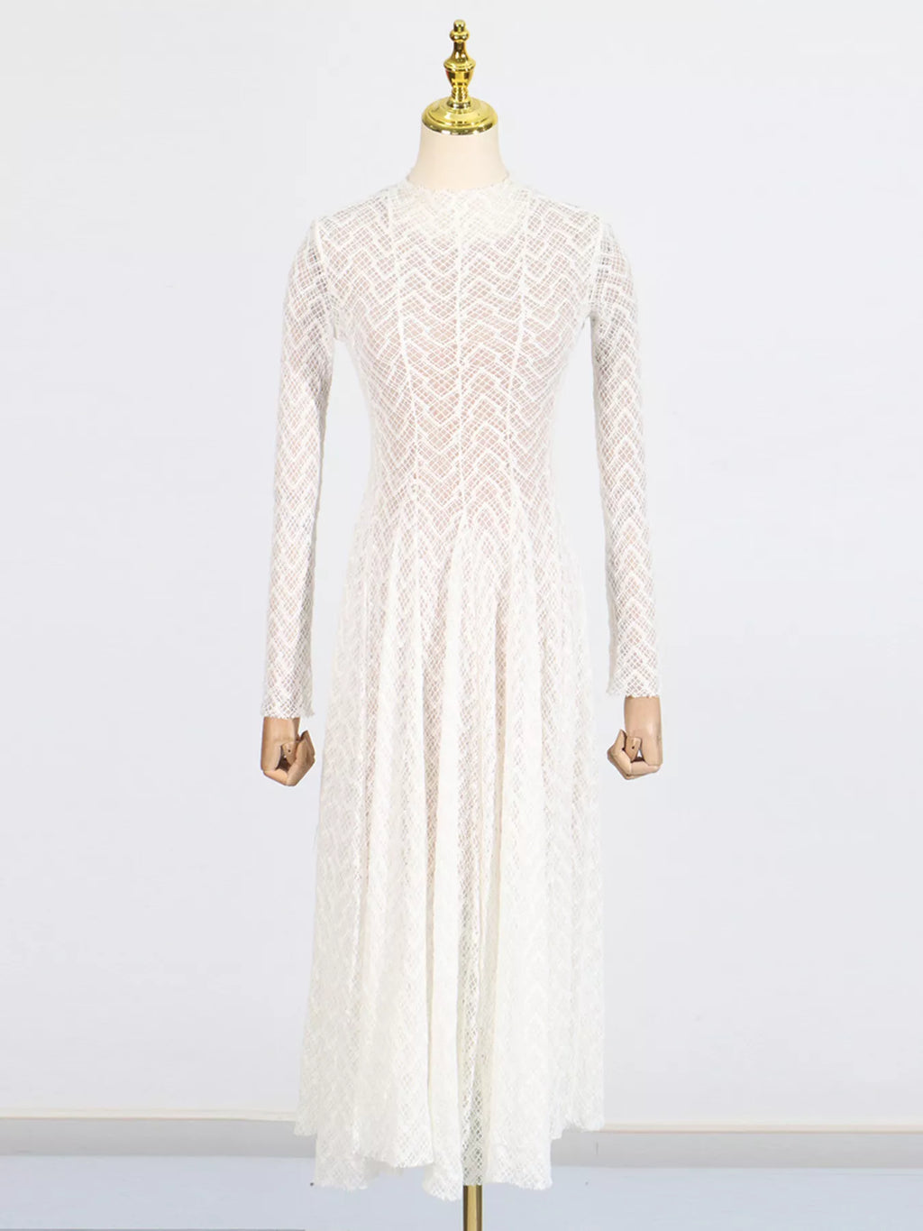 White lace mock-neck maxi dress on mannequin, long sleeves and full skirt