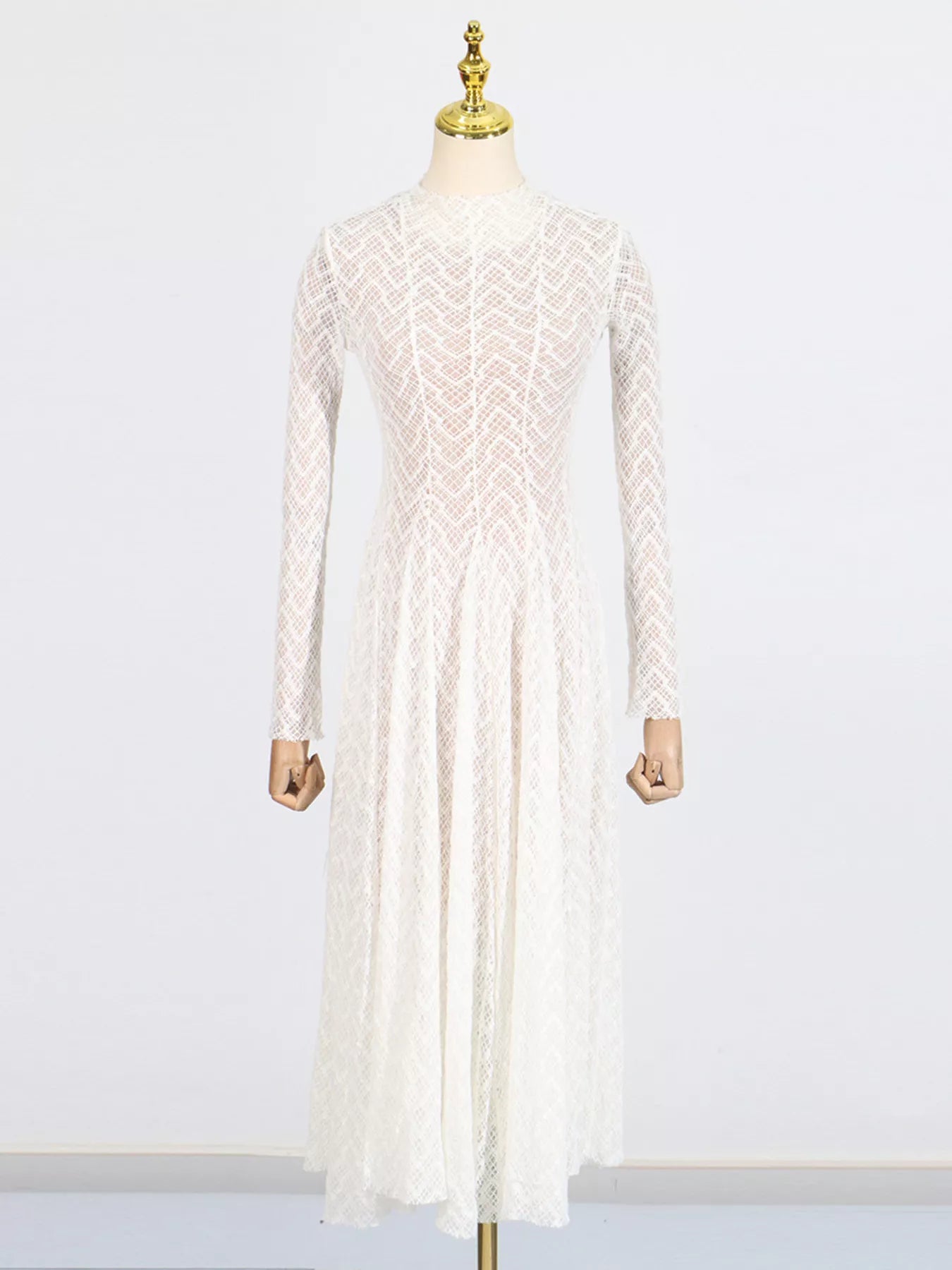 White lace mock-neck maxi dress on mannequin, long sleeves and full skirt