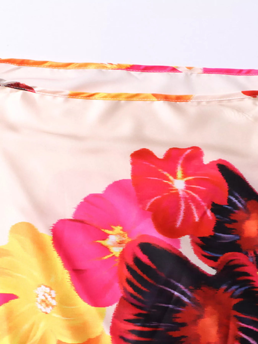 Close-up of multicolor floral print on white off-shoulder top fabric