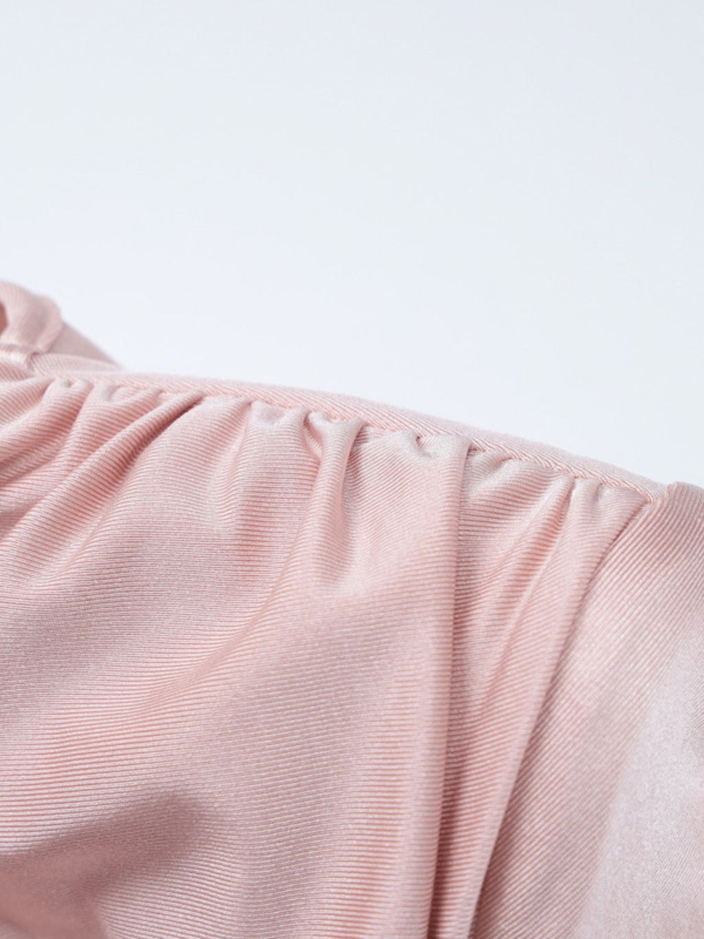 Soft pink ruched fabric section from a knot-front long sleeve maxi dress