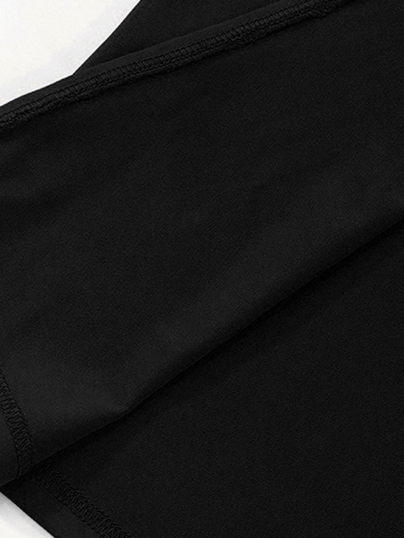 Close-up of black dress fabric with visible edge stitching and seam line