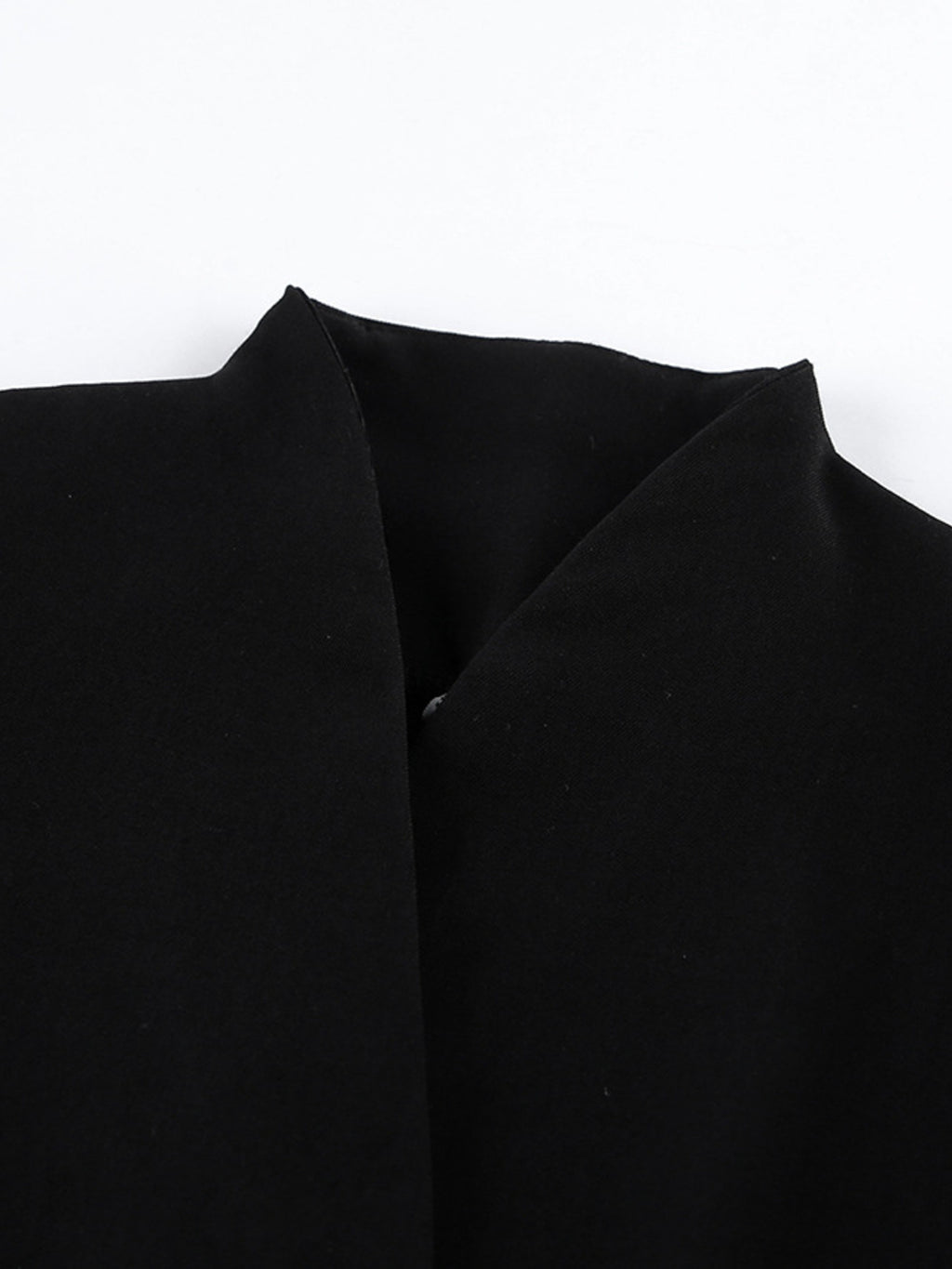 Black blazer dress lapel area with structured shoulder and seam lines