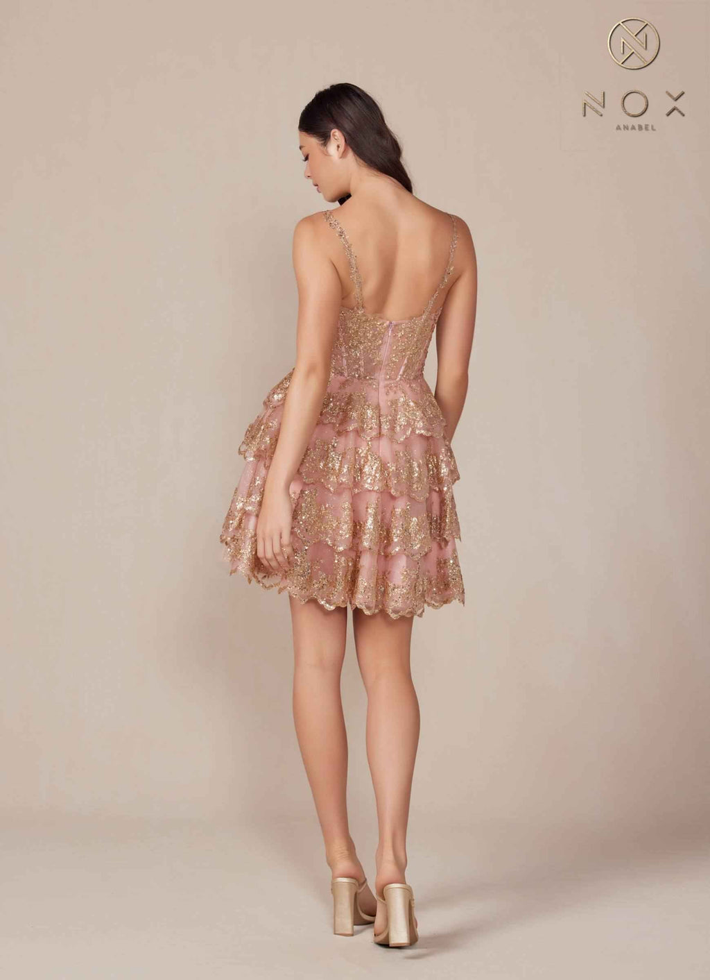 Back view of the rose gold tiered A-line dress by Nox Anabel, showcasing its sparkling design and tiered silhouette.