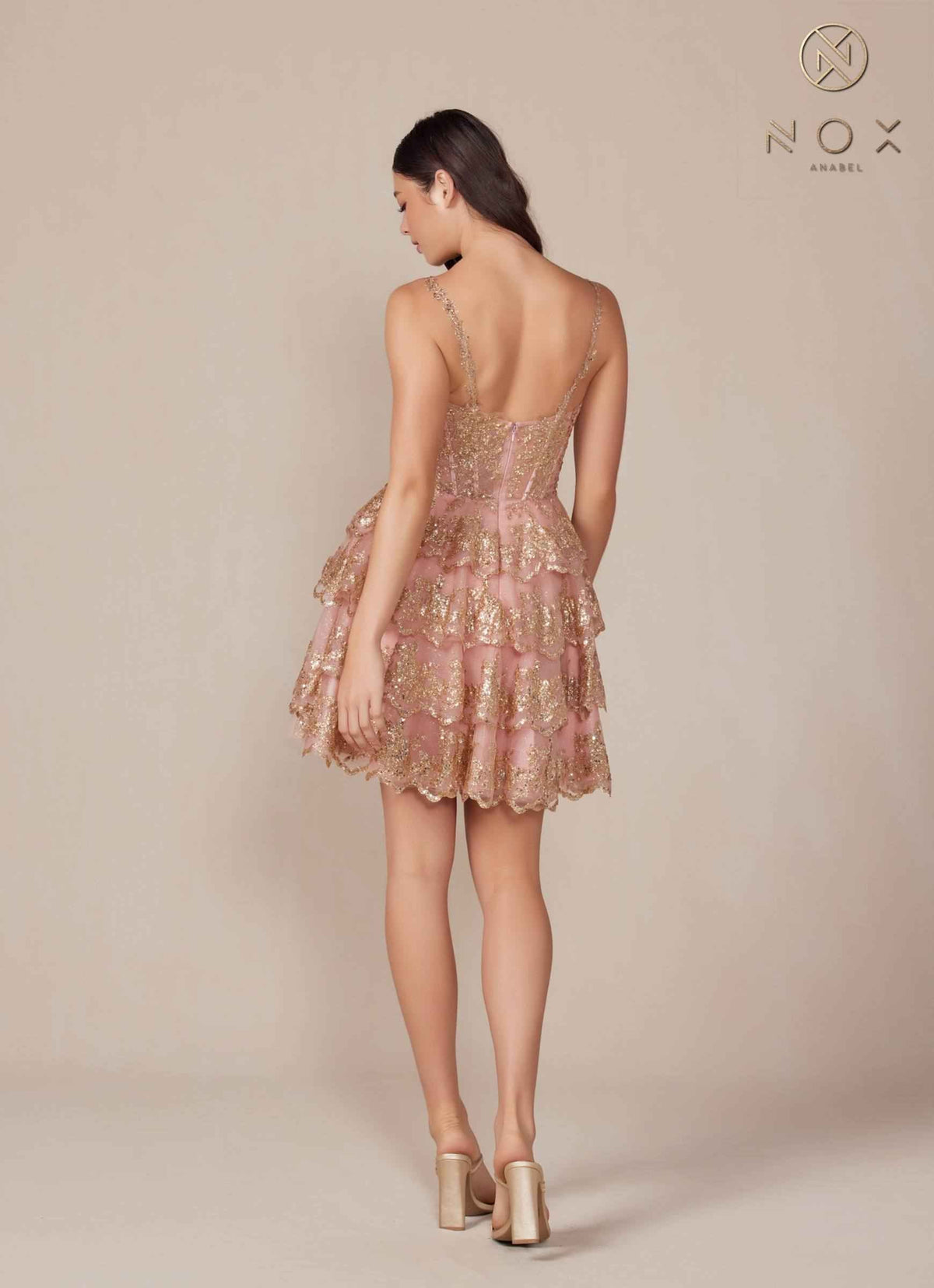 Back view of the rose gold tiered A-line dress by Nox Anabel, showcasing its sparkling design and tiered silhouette.